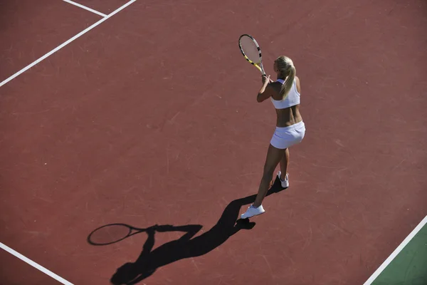 Mladá žena hrát tenis venkovní — Stock fotografie