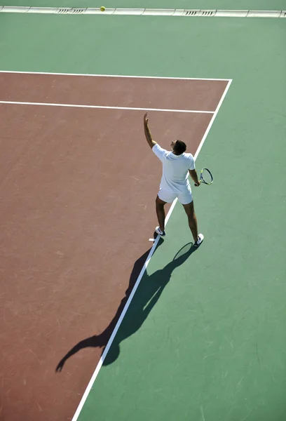 Молодой человек играет в теннис — стоковое фото