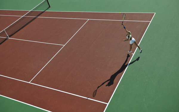 Молодая женщина играет в теннис на открытом воздухе
