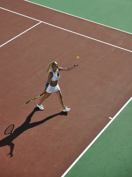Ung kvinna spela tennis utomhus — Stockfoto