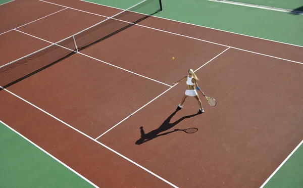 Молодая женщина играет в теннис на открытом воздухе — стоковое фото