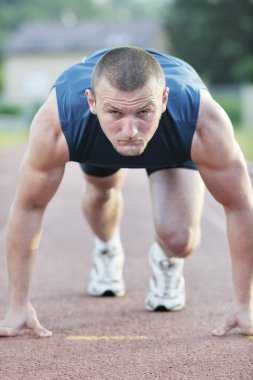 Healthy young man at start line ready for run race and win