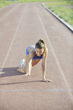 Young woman finaly passing finis line at athletics running race track clipart