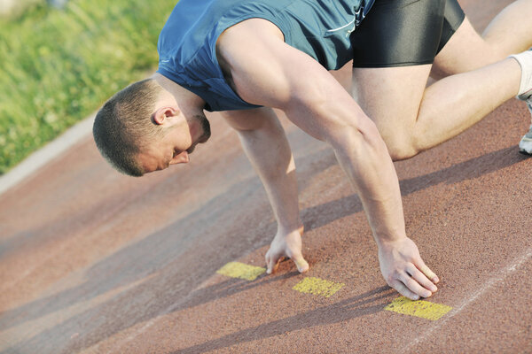 Healthy young man at start line ready for run race and win