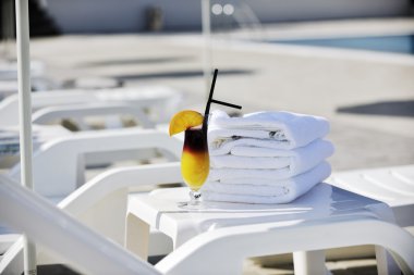 Coctail dring with orange att sunny day on swimming pool side with white towel decoraton clipart