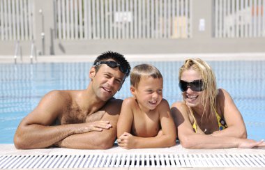 Mutlu genç aile yaz tatilinde yüzme havuzunda iyi eğlenceler.