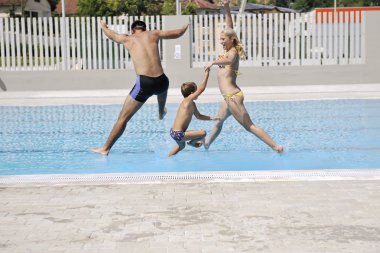 Mutlu genç aile yaz tatilinde yüzme havuzunda iyi eğlenceler.