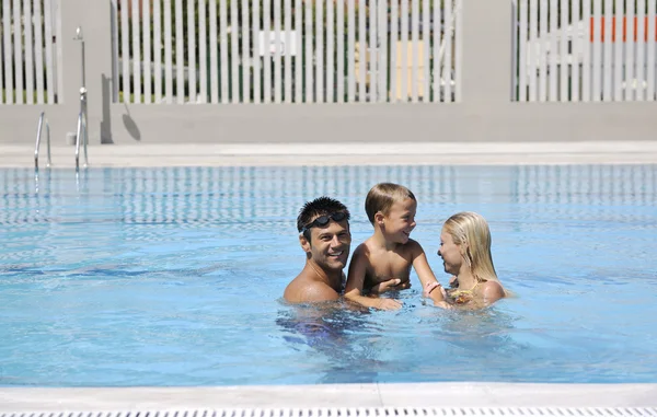 幸せな若い家族はプールで楽しんでいます — ストック写真