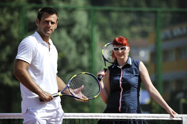 Feliz joven pareja jugar al tenis juego al aire libre — Foto de Stock