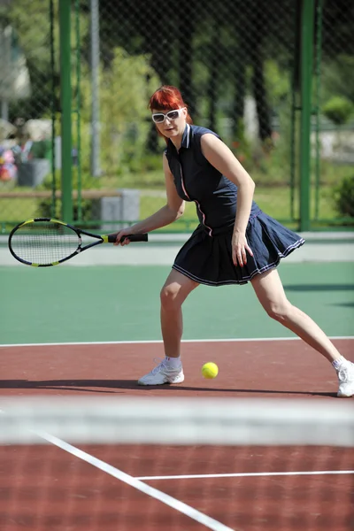 Ung kvinna spela tennisspel utomhus — Stockfoto