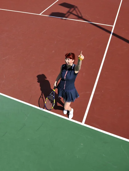 Mladá žena hrát tenis venkovní — Stock fotografie