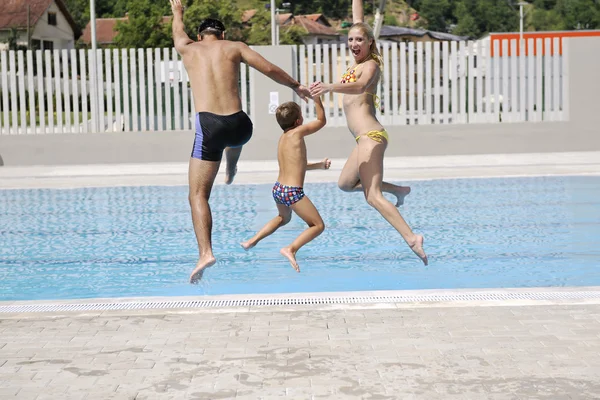 Lycklig ung familj ha kul på poolen — Stockfoto