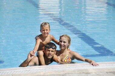 Mutlu genç aile yüzme havuzunda iyi eğlenceler.