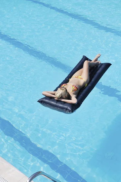 Güzel bir kadın yüzme havuzunda rahatlar. — Stok fotoğraf