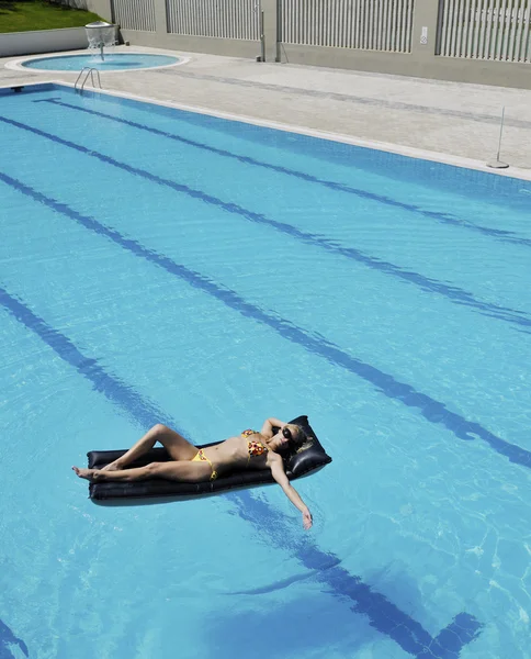 Hermosa mujer relajarse en la piscina — Foto de Stock