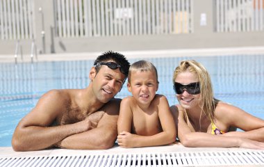 Mutlu genç aile yüzme havuzunda iyi eğlenceler.