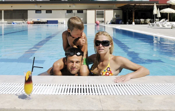 Feliz familia joven divertirse en la piscina — Foto de Stock