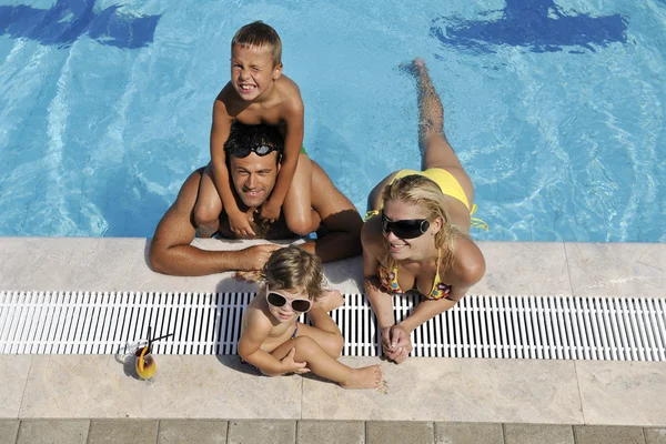 Щаслива молода сім'я розважається на басейні — стокове фото
