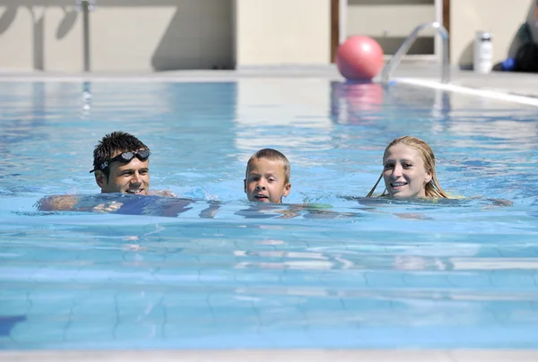 幸せな若い家族はプールで楽しんでいます — ストック写真