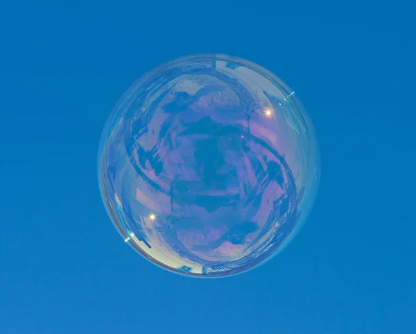 Большой мыльный пузырь над синим небом — стоковое фото