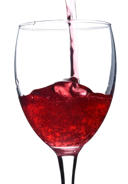 Pouring red wine in glass with bubbles — Stok fotoğraf