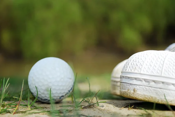 Golfball und Schuhe — Stockfoto