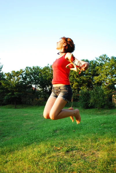 Happy woman jumping on grass — Stock Photo, Image