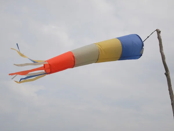 A windsock inflated by the wind against a cloudy sky. — Stock Photo, Image