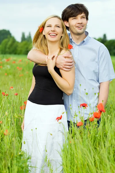 Sonriendo feliz pareja en archivado de amapola —  Fotos de Stock