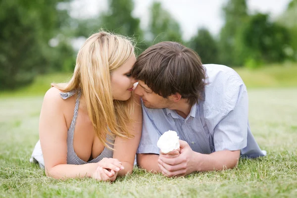 Young happy couple laying on grass — Stock Photo, Image