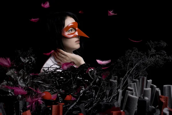 Das Mädchen mit den schwarzen Haaren und der roten Maske — Stockfoto