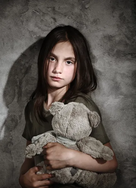 Грустная маленькая девочка с игрушкой — стоковое фото