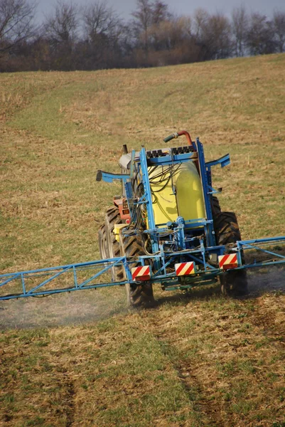 Farm machinery spraying field — Stock Photo, Image