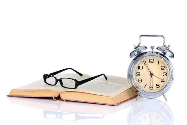 Könyv, ébresztőórával és szemüvegek — Stock Fotó