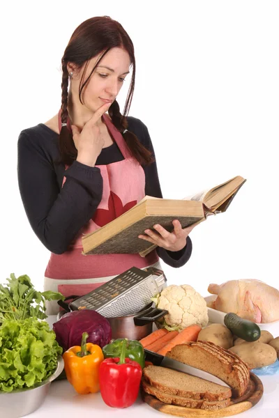 Huisvrouw denken met een recept boek — Stockfoto