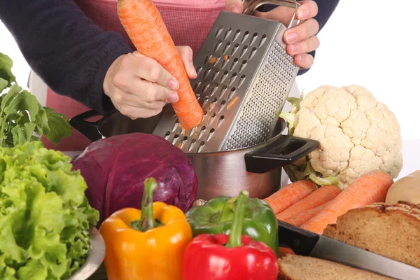 Cutting carrot with stainless grater — Stock Photo, Image