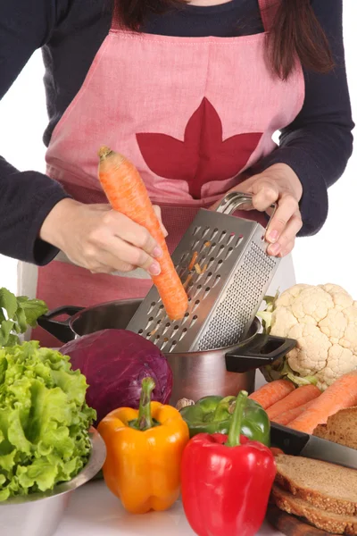 Cutting carrot with stainless grater — Stock Photo, Image