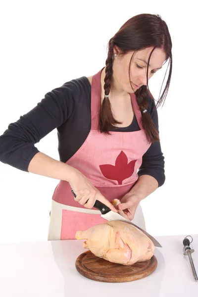 Prachtige huisvrouw snijden kip — Stockfoto