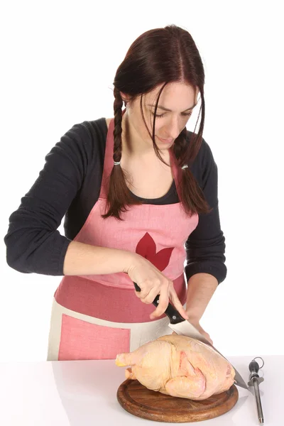 Schöne Hausfrau schneidet Huhn — Stockfoto