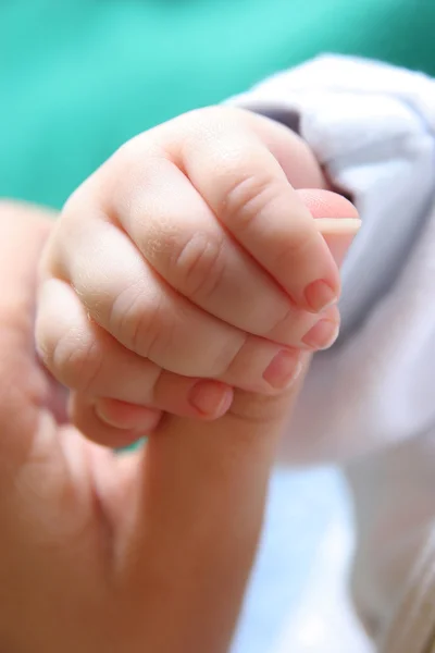 Hand des Neugeborenen greift nach dem Finger der Mutter — Stockfoto