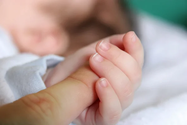 Рука новорожденного ребенка сжимает для матерей палец — стоковое фото