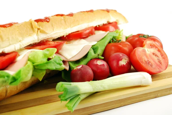 Большой сэндвич и овощи — стоковое фото