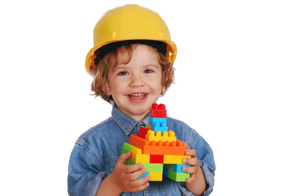 Маленька дівчинка будівельник з іграшковим блоком будинку — стокове фото