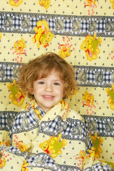 Boldog kis lány színes ágynemű — Stock Fotó