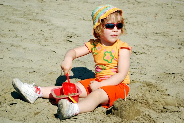Маленькая девочка играет на песке — стоковое фото