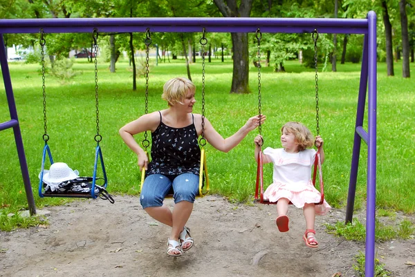 Happy mother and daughter on swing — Stock Photo, Image