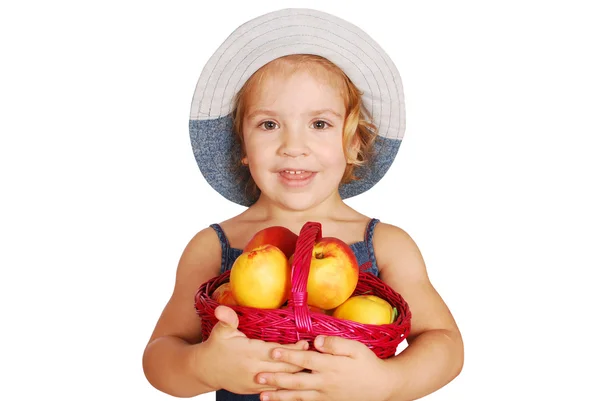 Liten flicka med korg med persikor — Stockfoto