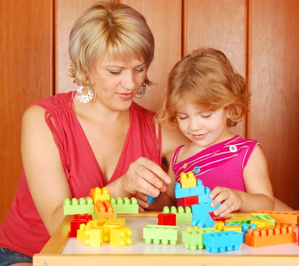 Mother and daughter play with toy brick — Stock Photo, Image