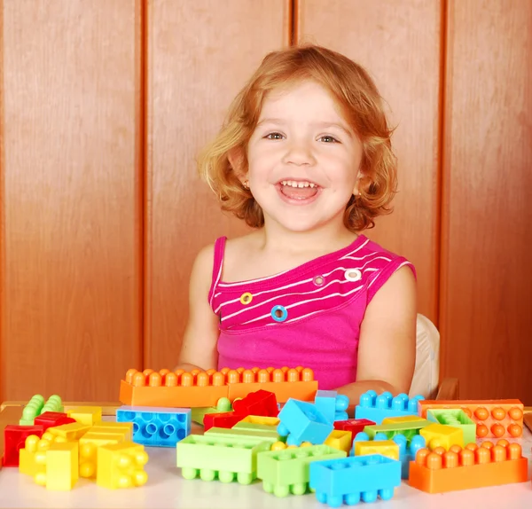 Menina feliz brincando com tijolo de brinquedo — Fotografia de Stock