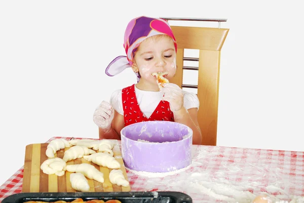 小さな女の子は、クロワッサンを食べる — ストック写真